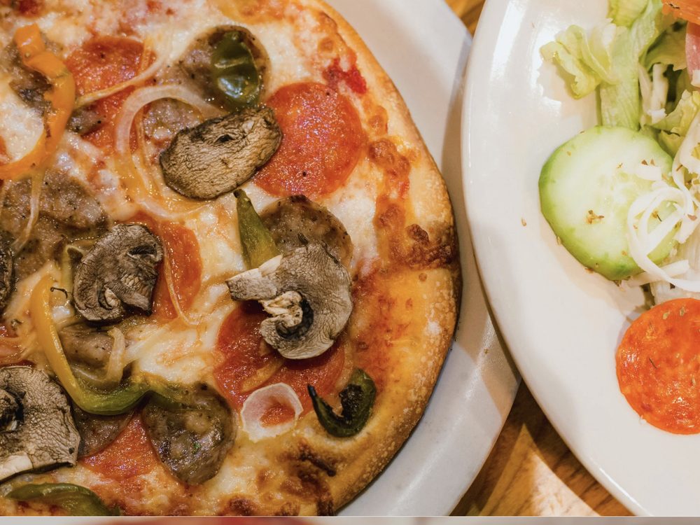 Luigi's Special pizza with pepperoni, mushrooms and peppers, with a side salad